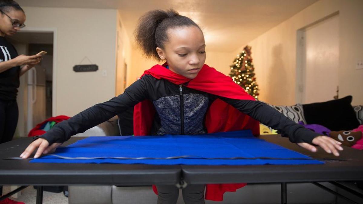 Paige Sullivan, 9, makes capes at her home in Chapel Hill on Saturday, December 17, 2016. The capes will be delivered to child patients at Duke University Hospital on Tuesday. Sullivan was born with a congenital heart defect and had it repaired at Duke over the summer. Her family and doctors kept calling her a little superhero and got her a cape. She decided other sick kids needed to embrace their inner superhero and has since made hundreds of capes this year to give to sick kids.
