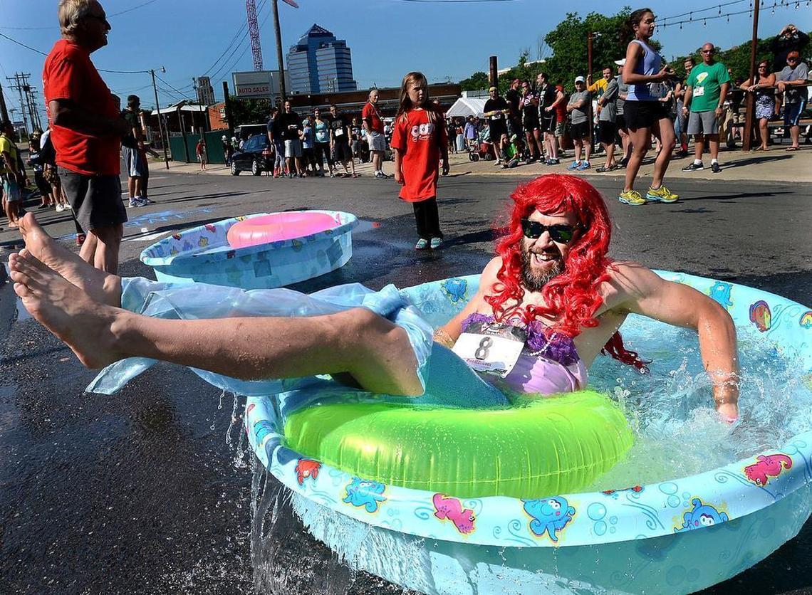 Jack Wiggen, dressed as the Little Mermaid’s "Ariel," does the mandatory seven spins on a tube in a kiddie pool as he competes in the Doughman race in Durham Saturday. The event combines food and sport to support SEEDS, a Durham non-profit .