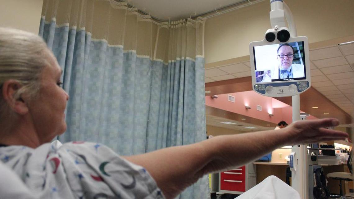 
Communicating remotely from the Jaycee Burn Center in Chapel Hill, Dr. Bruce Cairns inspects the arm of nurse Mary Butler in a demonstration of Johnston Health's new telemedicine robot.
