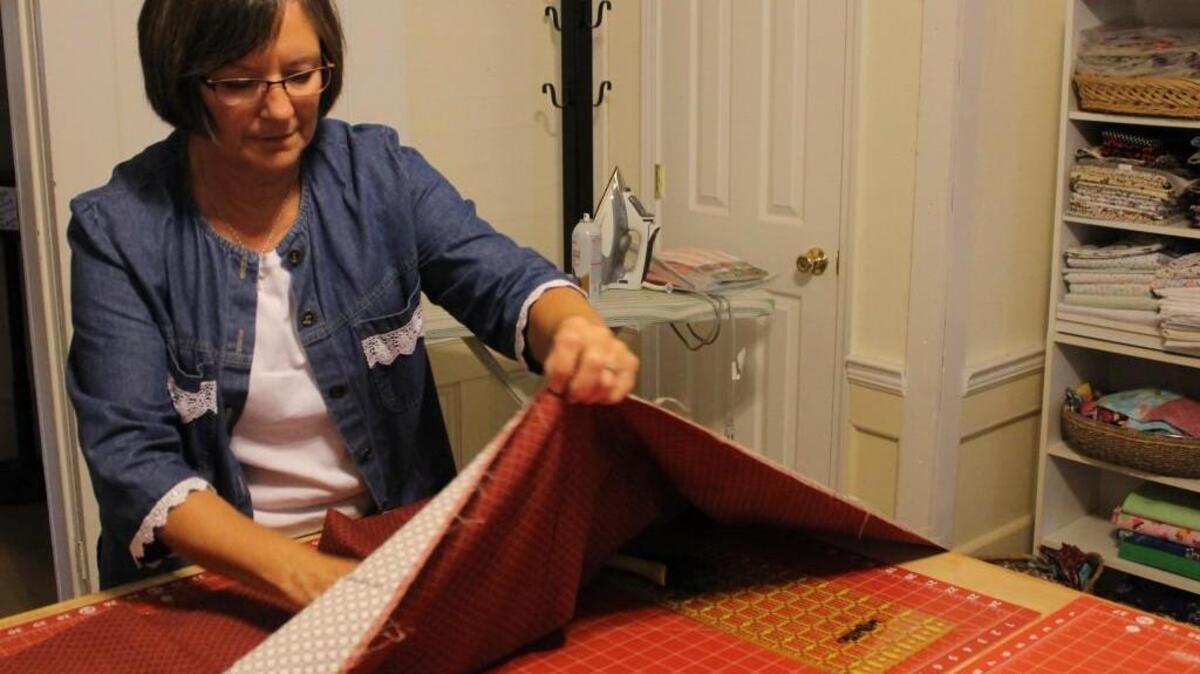 Julie Higgins of Fuquay-Varina measures fabric for a quilt at the Open Door Quilt House.