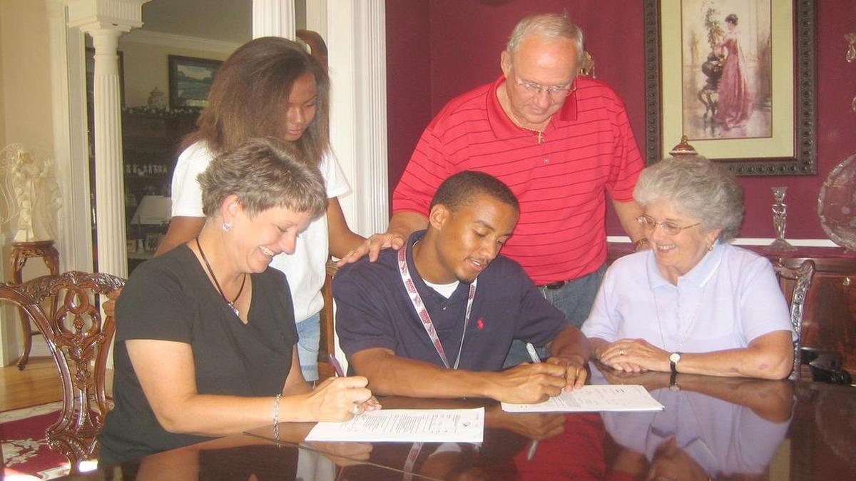 
Surrounded by his family, Middle Creek High School graduate Dylan Drayton signs to accept a baseball scholarship from N.C. Central University in August 2010. Drayton was killed in a motorcycle crash Thursday night in Johnston County.
