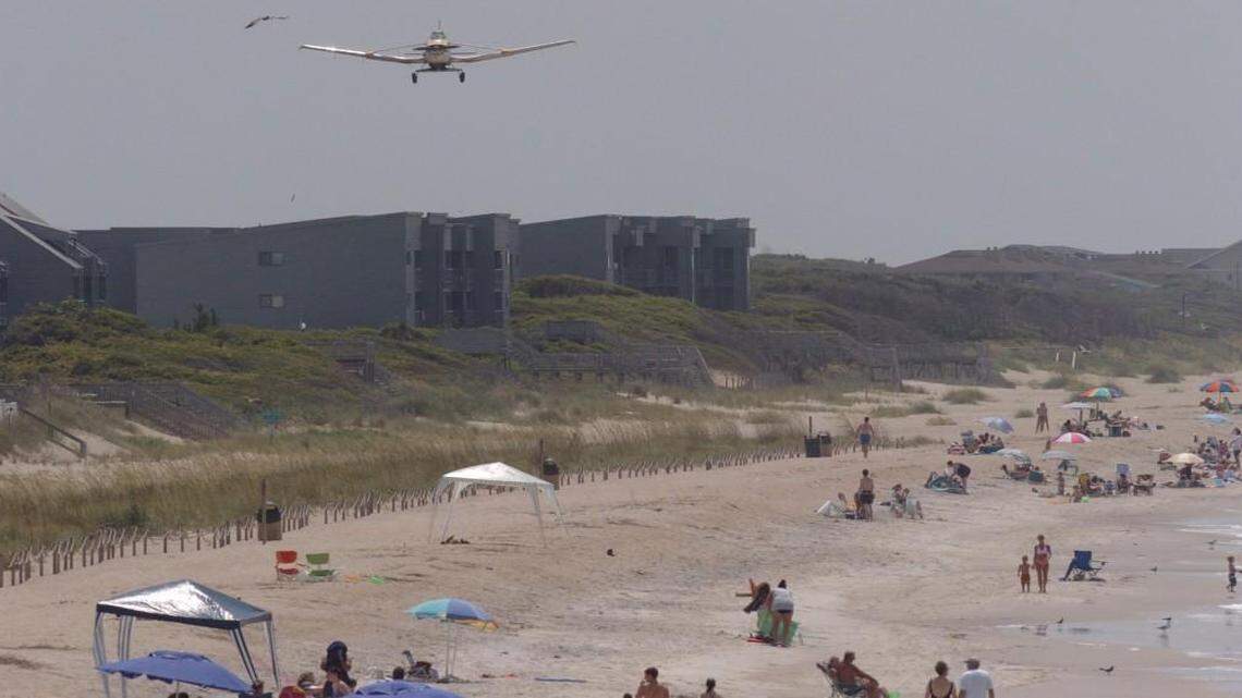 A crop duster spreads fertilizer along Caswell Beach, N.C., Tuesday, June 22, 2004. The crop duster spread six-tons of fertilizer on sea oats planted along Bald Head Island, Caswell Beach, Oak Island, and Sunset Beach in an effort to strengthen the plants that are so valuable to dune development. (AP Photo/The Star News, Jeffery S. Otto)