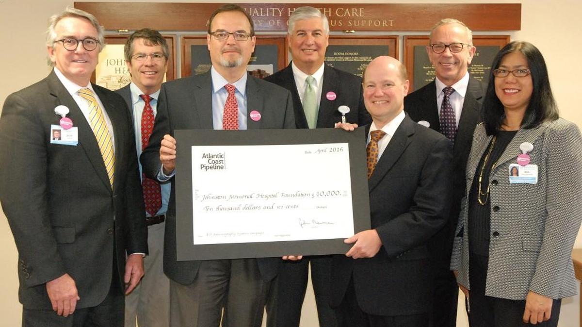 Johnston Health Foundation chairman David Mills, third from right, accepts a $10,000 check the check from Bruce McKay, senior energy policy director for Dominion. With them are, from left, County Commissioner Jeff Carver, a Johnston Health board member; Stewart McLeod, a foundation board member; Bobby Parker, chairman of the Johnston Health board; Chuck Elliott, chief executive and president of Johnston Health; and Sol Halliburton, director of the foundation.
