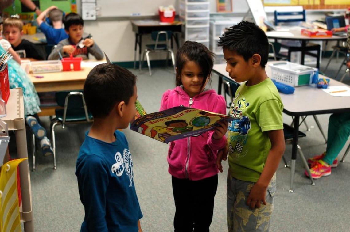 Cooper Elementary School kindergarteners look through a book in Julie Cauthren’s classroom. North Carolina school districts must now post online the titles of all books found in classrooms.