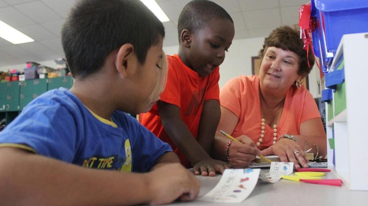 
Teacher assistant Donna Donovan helps Alexander Rodrigue, left, and Joshua Wright practice their ABCs.
