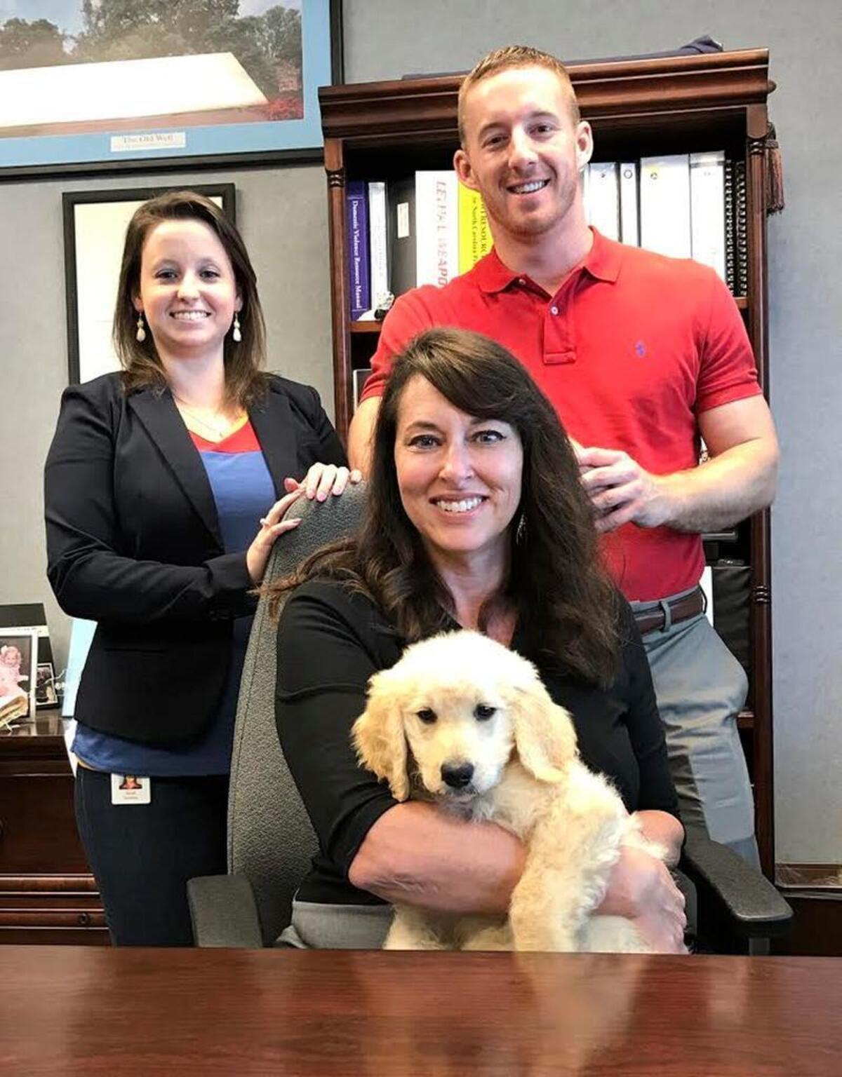A goldendoodle named “Teghan” will soon join the Johnston County District Attorney’s office, including, from left to right, legal assistant Sarah Cumbee, District Attorney Susan Doyle and assistant district attorney Jordan Ford. The office said Ford will be Teghan’s main handler.