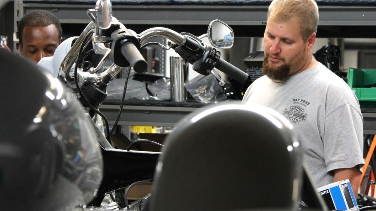 Jason Beaver, right, seen through shelves of custom motorcycle parts, talks with a customer at his shop in Selma.