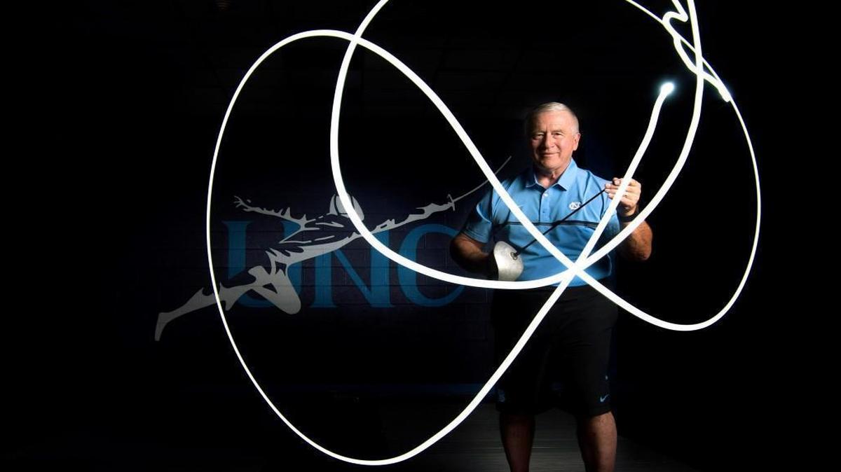 UNC fencing coach, Ron Miller, uses a sabre with a small LED light attached to trace the movement of the blade during a long-exposure photograph.