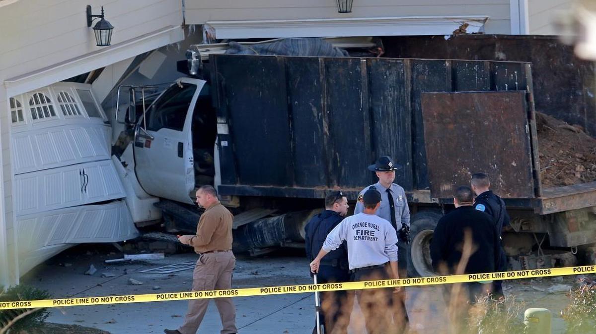 Hillsborough officials look over the scene on Dogwood Bloom Lane where a truck fatally injured a child and crashed into a home.