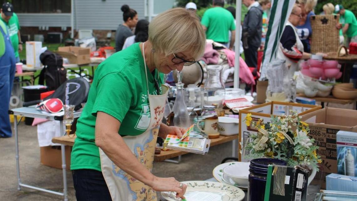 Marina Cook, a member of Friends of Crooked Creek, prices items at the group’s yard sale on Saturday in Fuquay-Varina. The Friends of Crooked Creek hoped to raise at least $2,000 from the yard sale for legal fees associated with its lawsuit to save the neighborhood’s golf course.