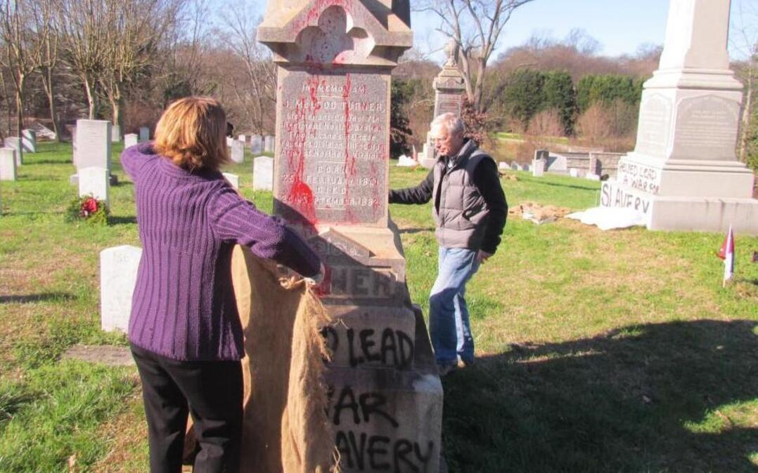Robin Simonton, executive director of Oakwood Cemetery, and Raleigh historian Bruce Miller work to cover graffiti painted on nine grave markers and monuments, mostly in the Confederate section. Damage is estimated at $20,000.