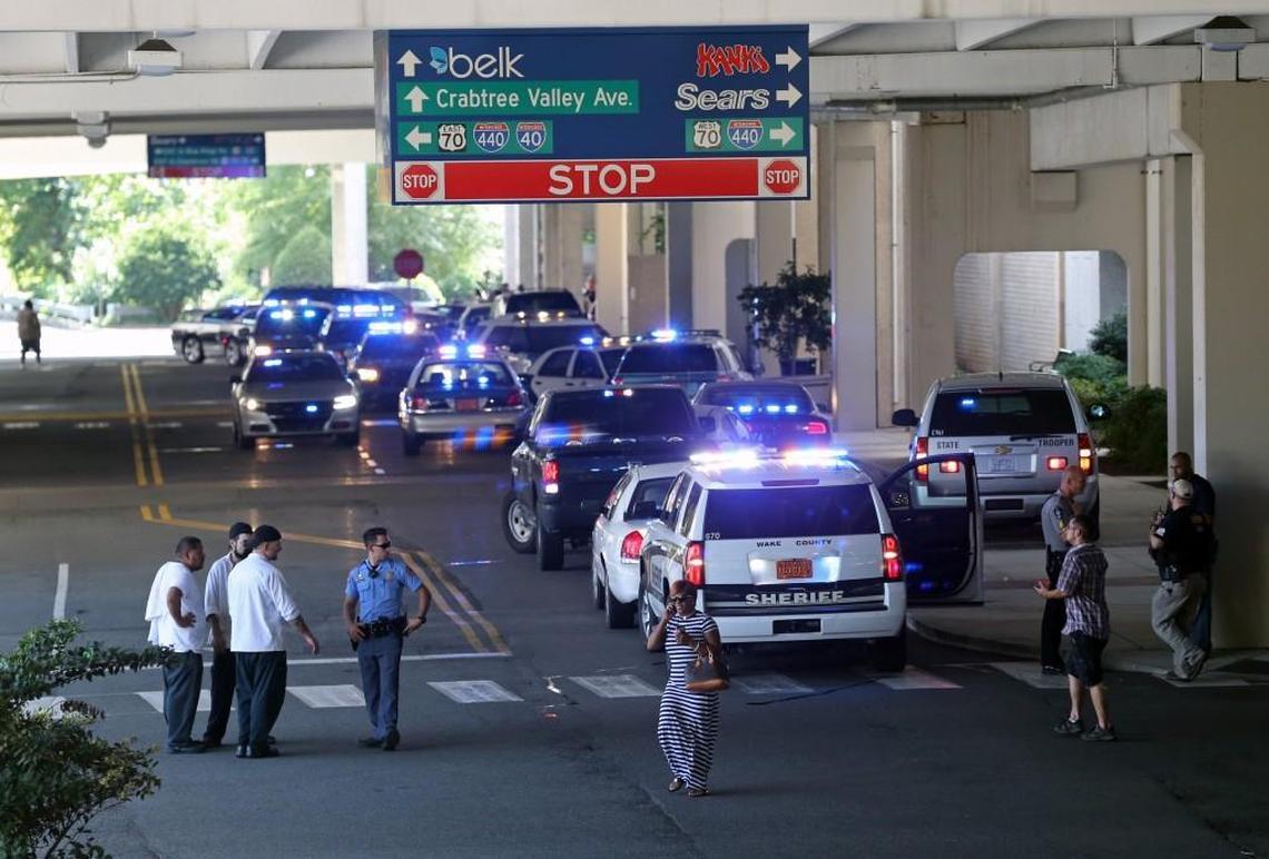Police and other official vehicles gather near the entrance to Belks as workers and customers leave as Crabtree Valley Mall in Raleigh was evacuated after shots were fired in the mall Saturday afternoon, August 13, 2016. All roads around the mall, including Glenwood Ave. and some exits on the Beltline were closed for hours due to the incident.