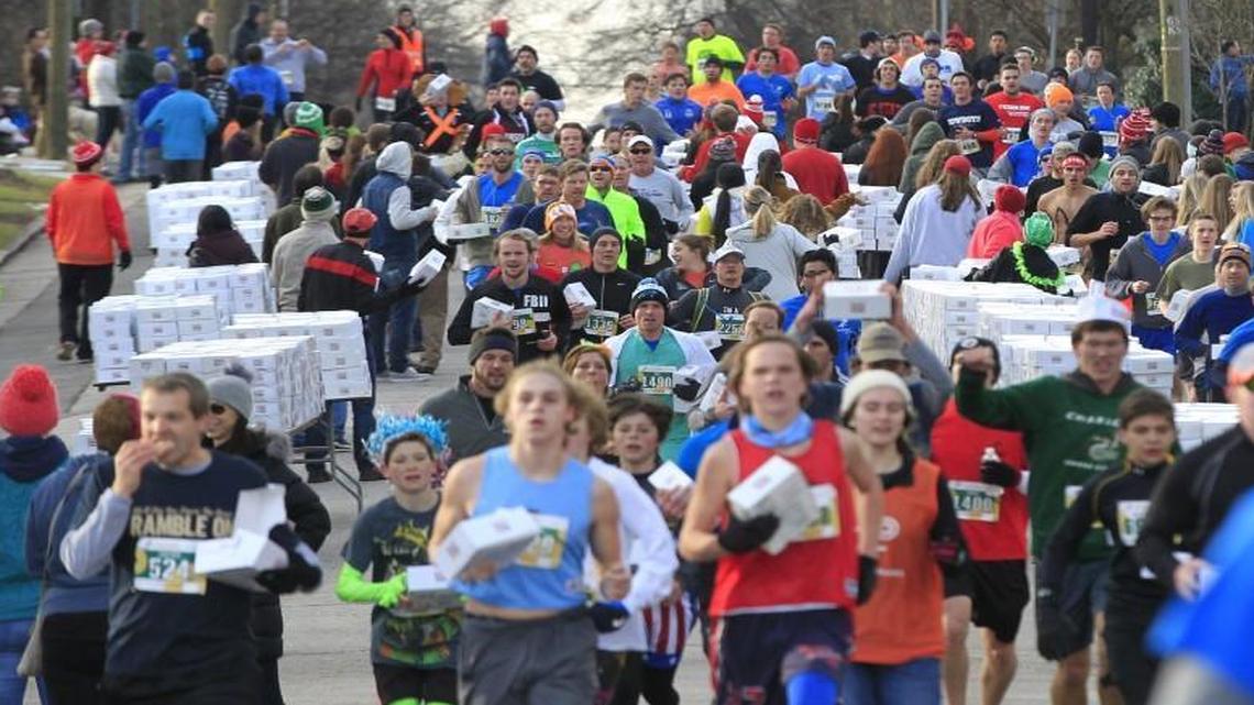 Some of the thousands of runners head down N. Person St. after picking up their doughnuts during the 12th annual Krispy Kreme Challenge race in Raleigh on Saturday.
