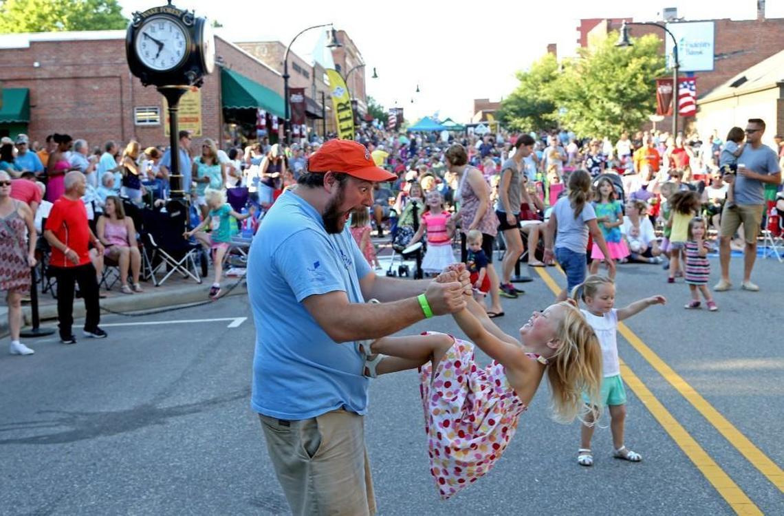 Rob James and his daughter Cecelia James have a blast dancing to the music as the town of Wake Forest holds Friday Night on White, an outdoor concert series.