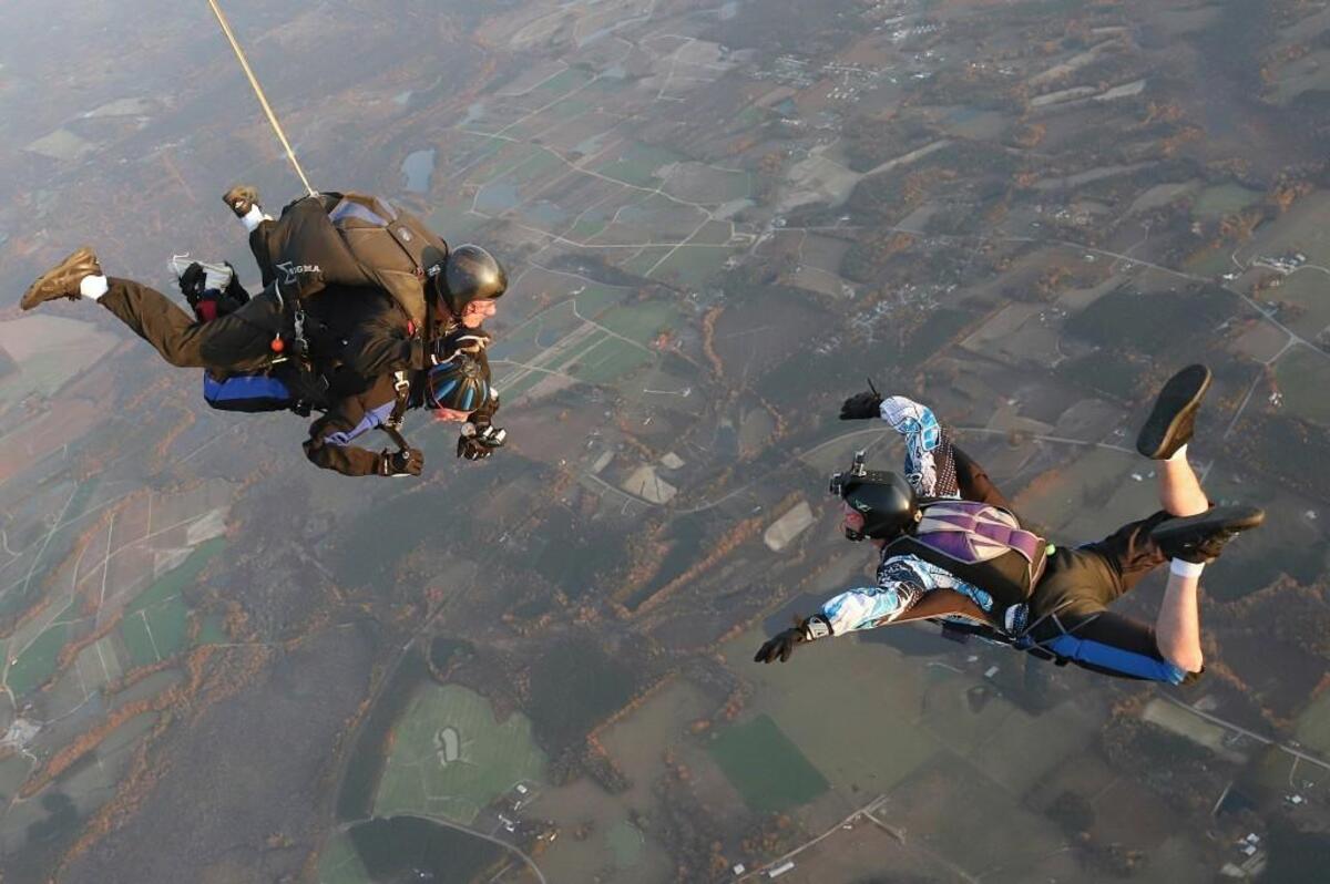 Doug Gross, 93, a World War II veteran, botton left, parachutes into Triangle Skydiving Center in Louisburg on Nov. 11, 2017.