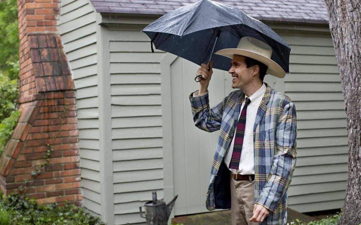 
Matthew Brown takes shelter from the rain beneath his umbrella during a historic house and gardens tour at Russ Stephenson's Oberlin Road home on Sunday.
