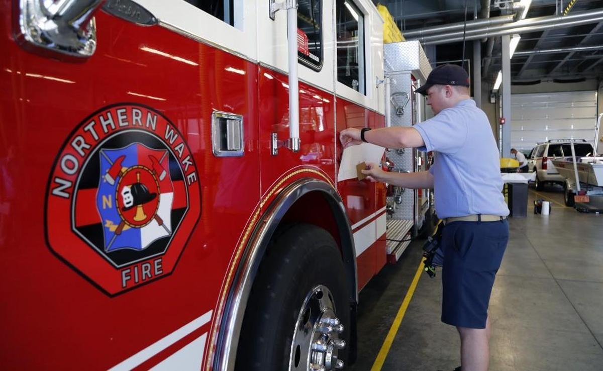 Scott Gordon puts the new decals on one of the trucks in preparation of the Bay Leaf and Stony Hill fire departments merging on July 1. He is at the Bay Leaf fire station on Six Forks Rd. north of Raleigh on June, 26, 2017. The merged group will be known as the Northern Wake Fire Department.