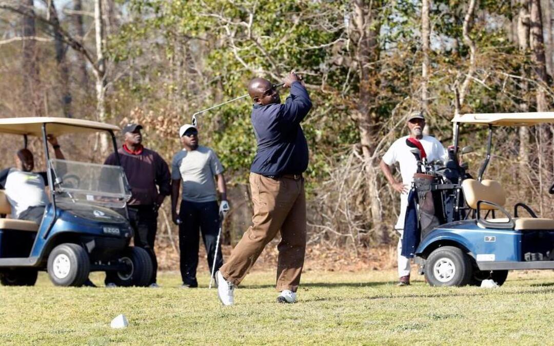 Chalmers Hinton, center, tees off while his golfing buddies watch at Meadowbrook Country Club in Garner on March 23, 2016.