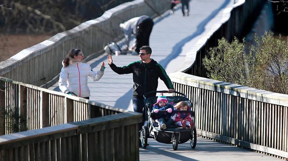 Robyn and James Showanes of Raleigh give each other a high five as they complete the elevated walkway part of the three-mile Johnson Lake Park trail with their kids and dog Saturday, January 2, 2016