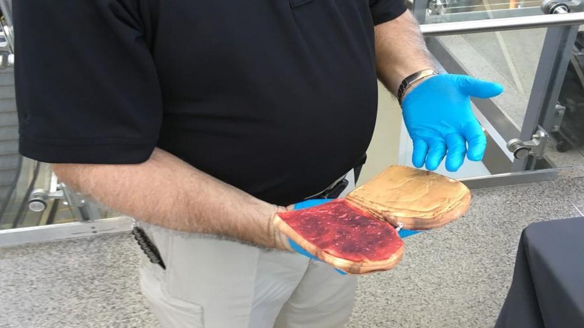 Tony Aguilera, an explosives specialist for the Transportation Security Administration, holds a fake peanut butter and jelly sandwich that he has used to conceal simulated explosives at TSA checkpoints to test screeners. Aguilera was speaking at a press conference at Raleigh-Durham International Airport on Friday, Oct. 6, 2017.