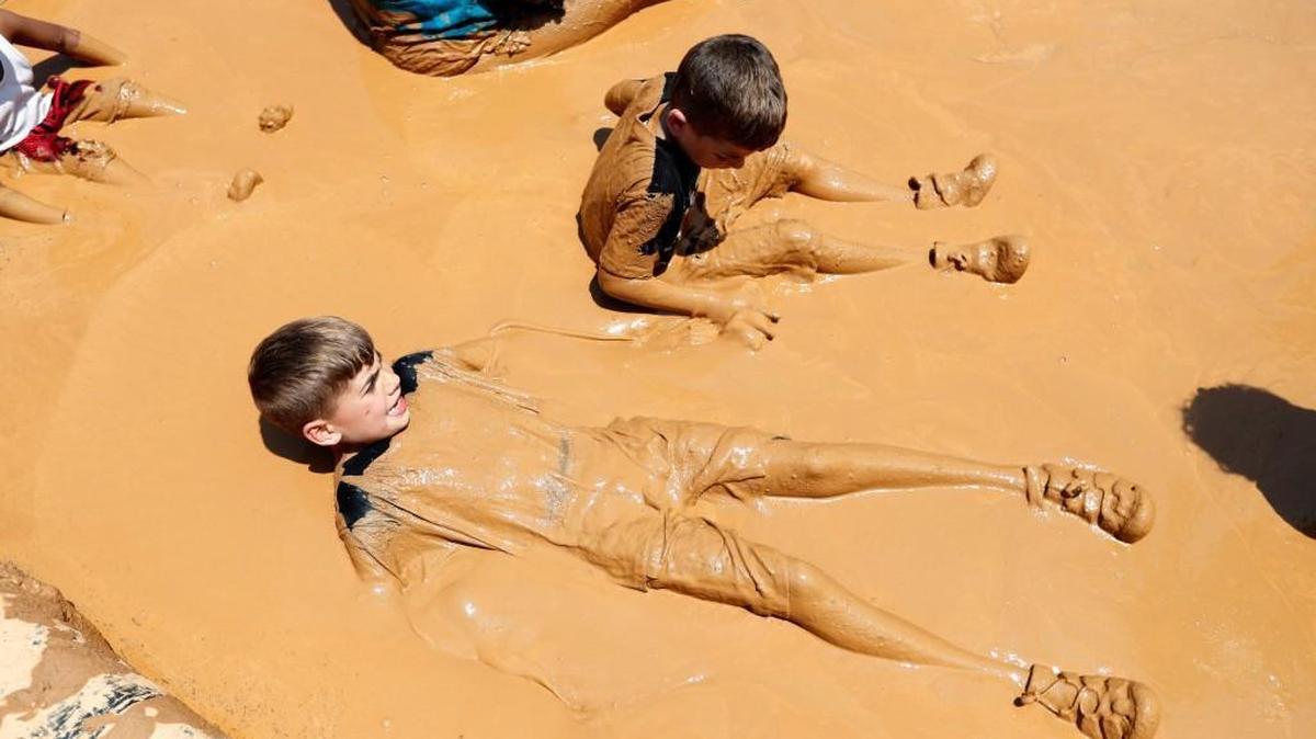 Mason Lampuri, 8, left, and his brother Rocco, 6, play in the mud pit during the first Mud Day at Walnut Creek Wetland Park in Raleigh on June 3, 2017.