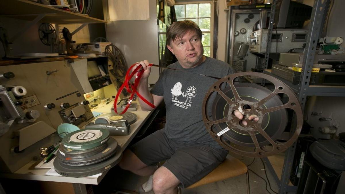 Skip Elsheimer, the founder of A/V Geeks, inspects a reel of film in his vast collection at his home on Thursday in Raleigh. Elsheimer has more than 24,000 educational 16mm films in his collection.