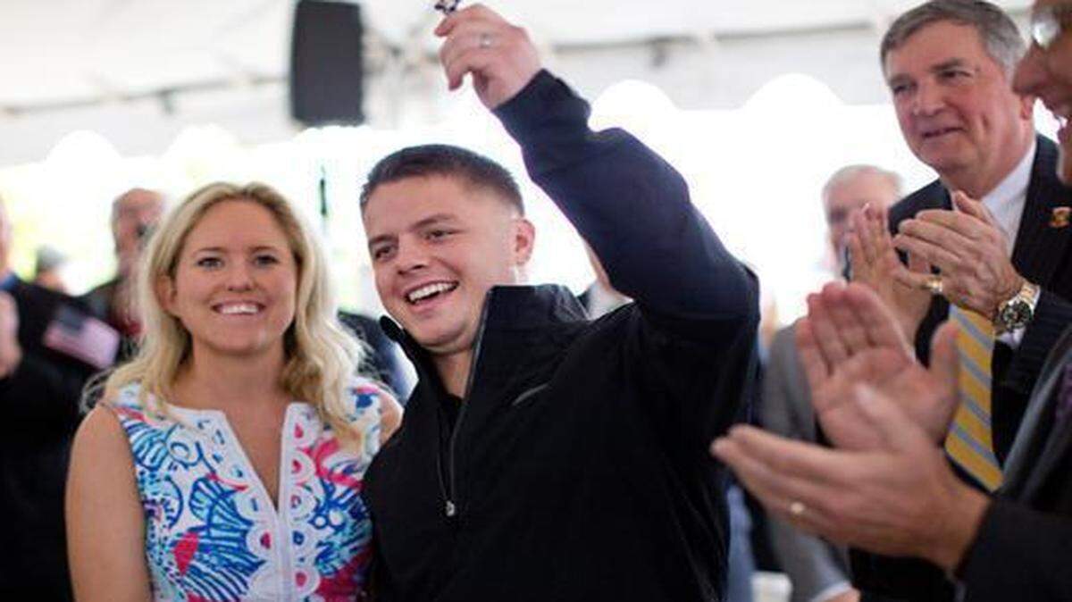 
U.S. Marine Corps Cpl. Ryan Wightman and his wife Melissa cheer after being presented with the keys to their new home. 
