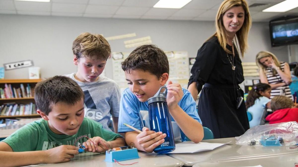 Fourth-grader teacher Katy Trainor, right, watches as, from left, Lucas Bedont, Ryan Olson and Matthew LaRusso take part in a lesson on electrical circuits at Salem Elementary School in Apex Wednesday, April 12, 2017.