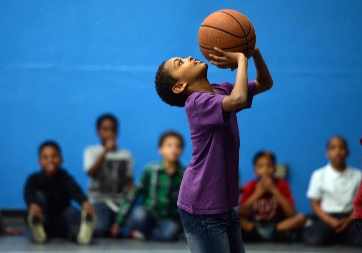 In this 2016 photo, 9-year-old Steven Bullock shoots baskets at the Wake County Boys & Girls Club in Raleigh. The club, which picks up kids after school, is being squeezed by higher fuel prices.
