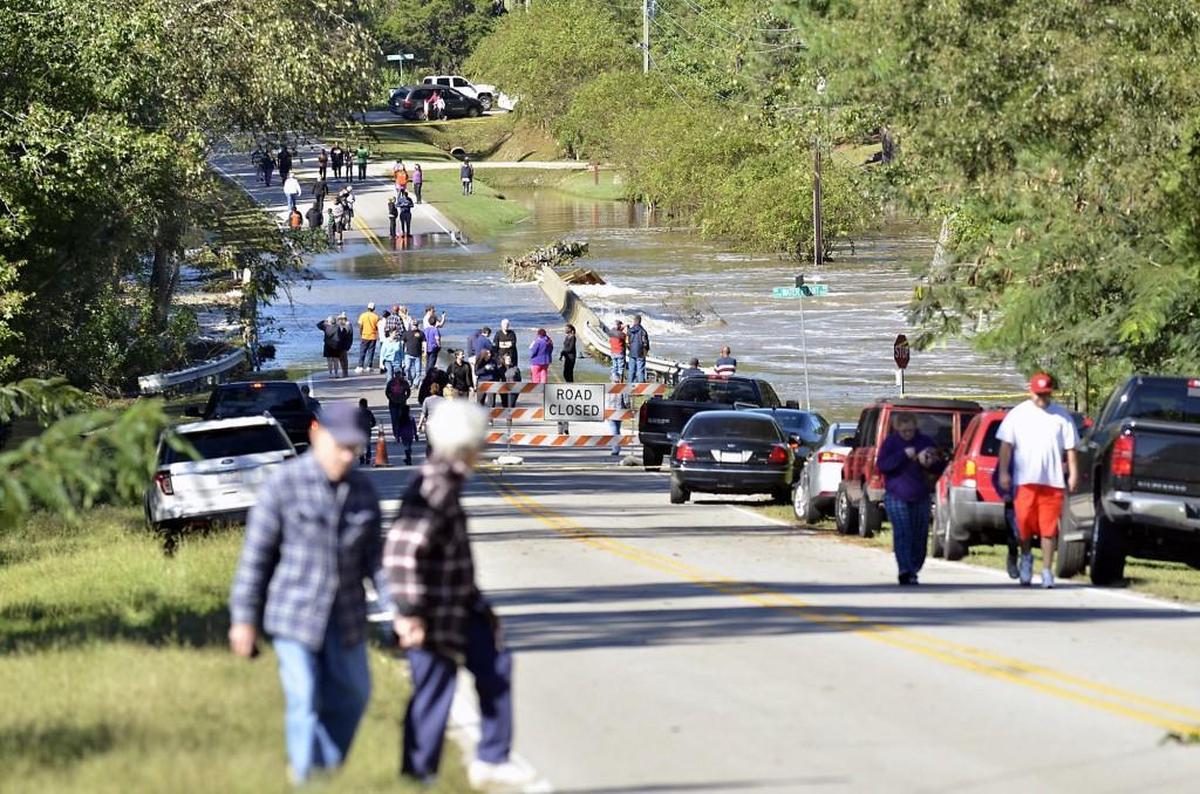 People assemble on both sides of the flooded bridge on N.C. 97 where the Little River overflow was nearly level with the dam after Hurricane Matthew in Zebulon, N.C. on Sunday, Oct. 9, 2016.