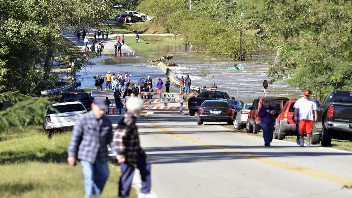 People assemble on both sides of the flooded bridge on N.C. 97 where the Little River overflow was nearly level with the dam after Hurricane Matthew in Zebulon, N.C. on Sunday, Oct. 9, 2016.