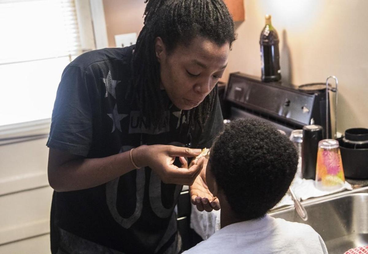 Vanessa Bates lets her 8-year-old son York Hatcher taste a hash brown while she cooks in her mother’s kitchen in Durham. Homeless and without a car, Bates has struggled to find steady employment and sleeps on the couches of family and friends. Bates says she usually waits until her children are done eating before she eats a meal, making certain certain her children have enough to food.