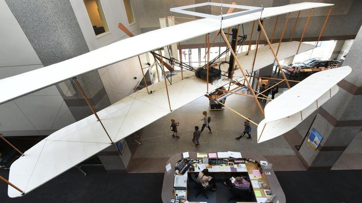 Visitors walk under a reproduction of the 1903 Wright Flyer at the N.C. Museum of History Thursday, Nov. 17, 2016 in Raleigh, N.C. The model from the Wright Brothers National Memorial Visitor Center in Kill Devil Hills, at the Outer Banks, is undergoing a rehabilitation project through summer of 2018. Prominently featured at the N.C. Museum of History, the 1903 Flyer creates an impressive sight for visitors entering the three-story lobby. The aircraft is suspended at a height of 12 feet, the same height of the Wright brothers’ first flight. On Dec. 17, 1903, Wilbur and Orville Wright successfully flew the first powered flight in Kill Devil Hills.