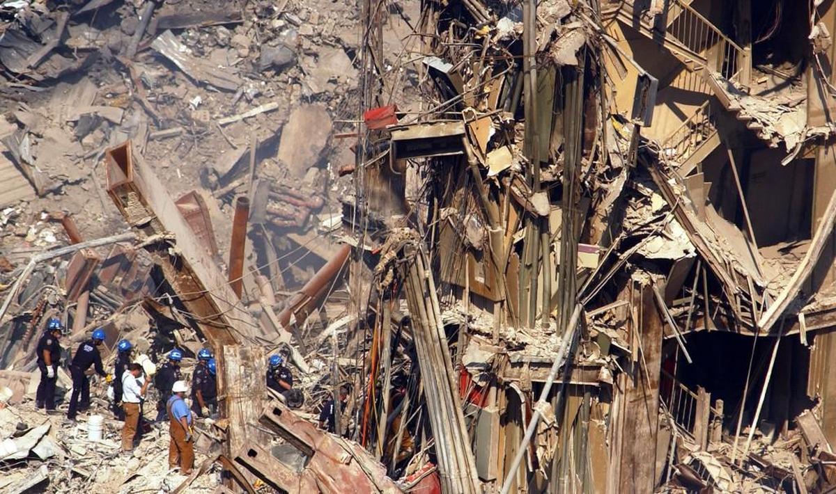 Rescue workers move toward the remains of a stairwell in the wreckage of the World Trade Center north tower in New York, Wednesday, Oct. 3, 2001.