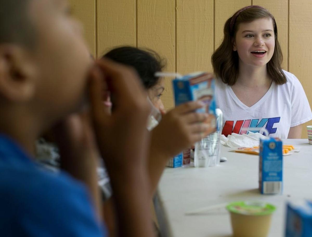Volunteer Jessie Collier talks nutrition with a group of children from the neighborhood around the Casa De Luna Apartments during a stop by the Dream Center of Raleigh on Tuesday, June 13, 2017 in Raleigh, N.C. Jeremy Porras started the Dream Center ministry in 2014. He has teamed with the Food Bank to provide nutritious lunches to children during the months they are not in school.