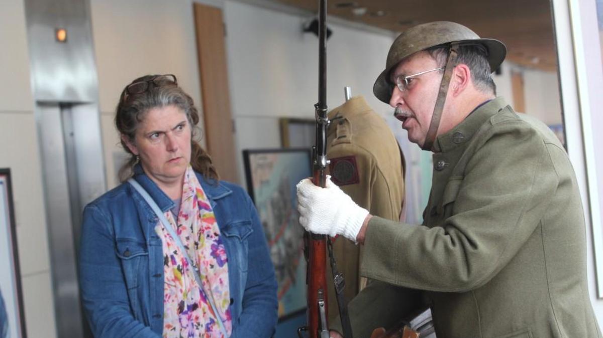 Beth Thomasson listens to a demonstration of World War I weaponry Saturday at the opening of the North Carolina in the Great War exhibition at the N.C. Museum of History in downtown Raleigh.