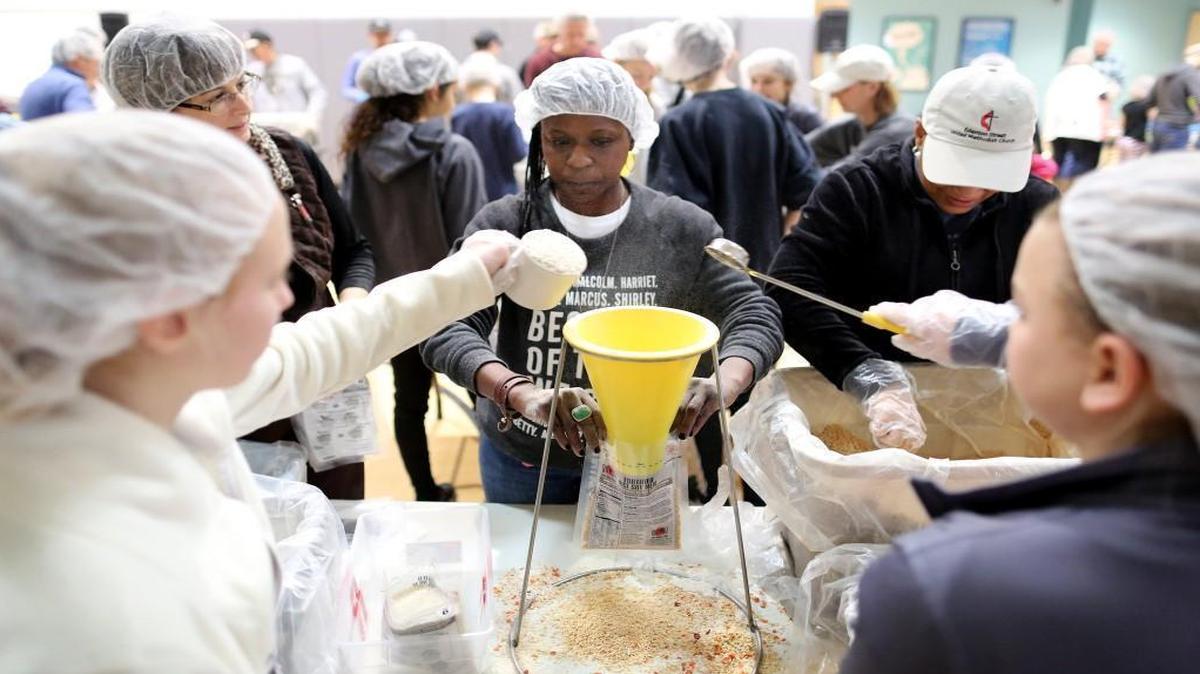 Lisa Yebuah, center, a pastor at Edenton Street United Methodist Church, assists in packing meals during a Stop Hunger Now event at the church on Dec. 17.