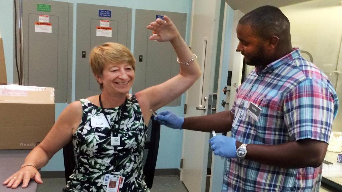
Bobby Ragin, a PhD student at North Carolina Central University, swabs volunteer Liz Baird’s armpit at the North Carolina Museum of Natural Sciences. Scientists at the museum will sequence the microbial DNA found in her sweat.
