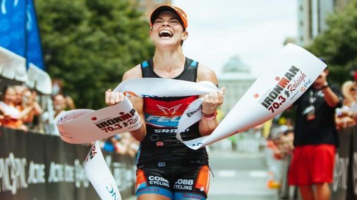 Lauren Barnett, of Leawood, KS, celebrates her victory at the finish line of the Ironman 70.3 Raleigh triathlon course in Raleigh on Sunday. Barnett was the top overall woman finisher of the race with an overall time of 4:21:04.