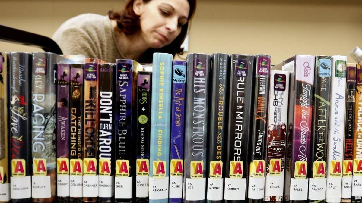 Sara Alcott checks books into the new library system on Tuesday at Northeast Regional Library. The new facility near Wakefield will likely ease crowding at the Wake Forest Community Library.