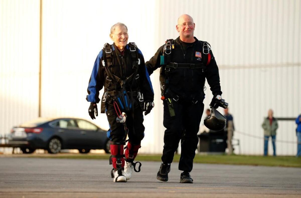 Doug Gross, left, heads to the plane with tandem instructor John Renfro as he readies to parachute into Triangle Skydiving Center in Louisburg on Saturday.