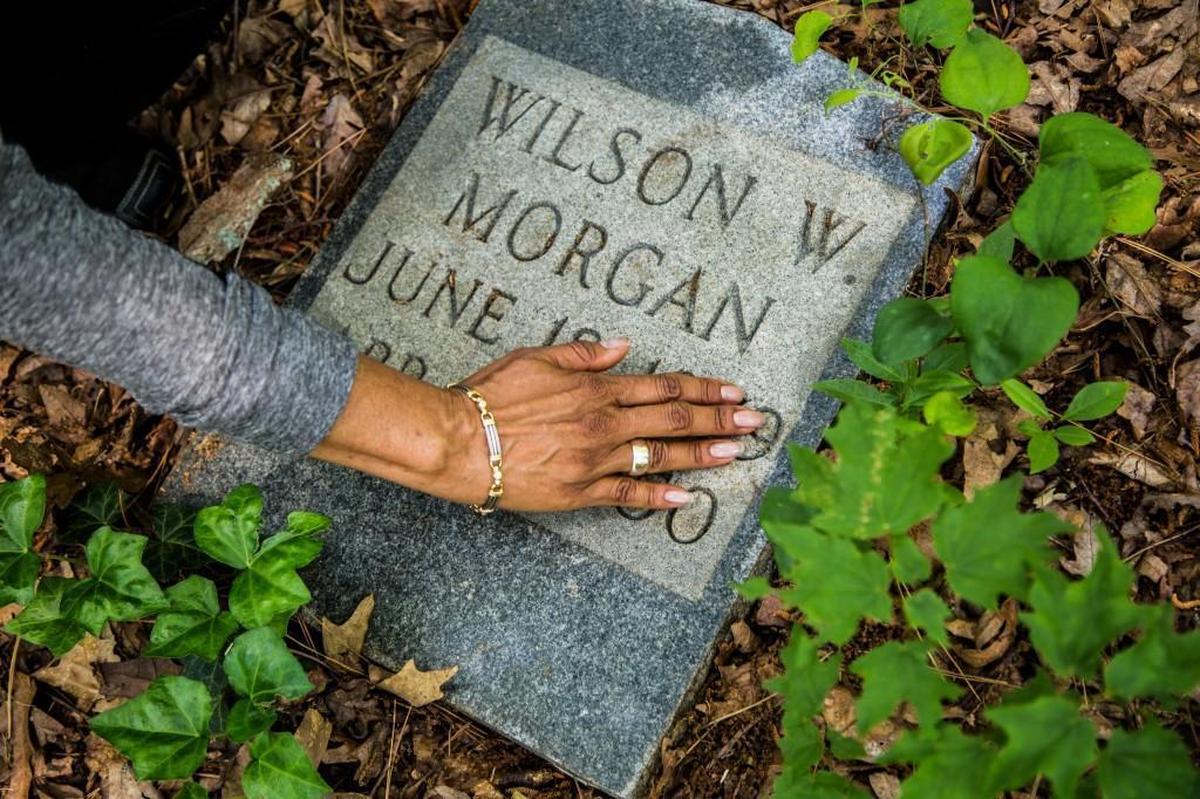 Sabrina Goode, who is descended from an early settler in Oberlin Village where many freedmen bought land and settled after the Civil War, clears debris from a grave stone at her family’s burial plot Tuesday, May 12, 2015 at the 3-acre Oberlin Cemetery near Cameron Village in Raleigh. Goode is a volunteer who has worked to care for Oberlin Cemetery, where there may be as many as 600 graves.