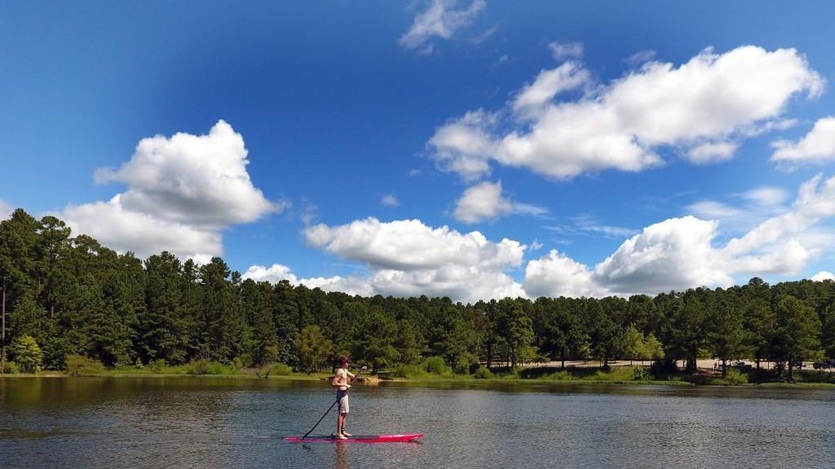 Bryce Tuton, 16, of Raleigh, N.C. paddles across the calm waters of Falls Lake at the Highway 50 boat ramp Friday, July 29, 2016. He and his father, Jason Tuton, took advantage of the perfect summer day to get in some practice while the lake was relatively empty of boat traffic.