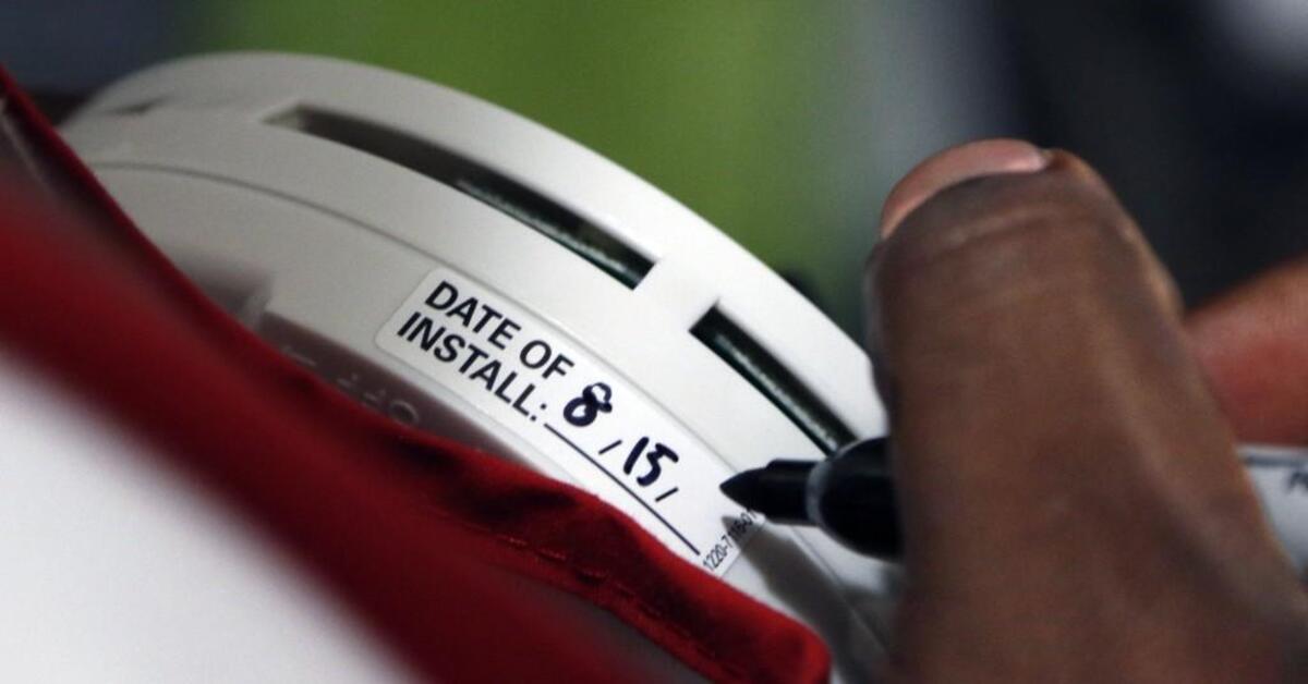 Red Cross fire safety volunteer installer William Brown notes in marker the date of installation of a new battery powered smoke alarm on an interior living room wall Saturday, August 15, 2015 at a residence in the Foxhall Village of Raleigh mobile home park. Brown was part of a team of four Red Cross fire safety workers that were part of a larger group that underwent training in fire safety and smoke alarm installation at the Peartree Lane Red Cross center Saturday morning before setting out in teams of four to canvas in neighborhoods in northeast Raleigh and in Knightdale if they had working smoke alarms or needed them in their homes. The smoke alarms were installed free of charge.
