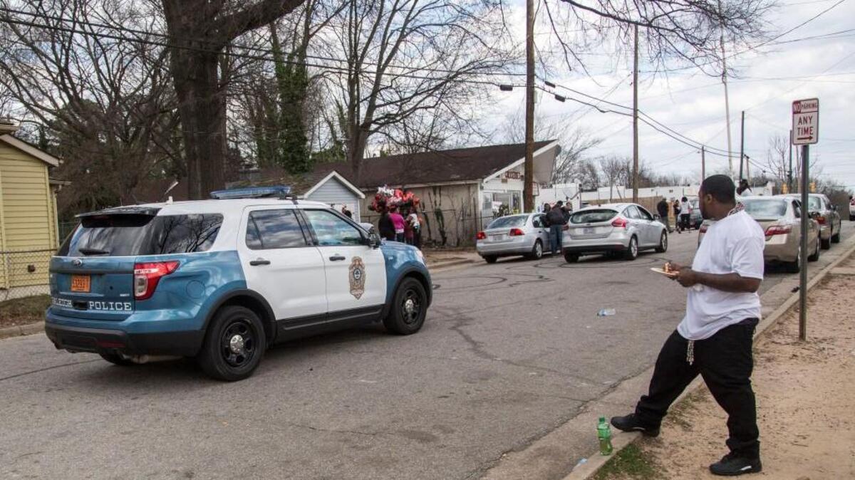 A Raleigh police vehicle drives past the scene of a makeshift memorial Tuesday, March 1, 2016 near the intersection of Bragg and South East Streets in Raleigh where Akiel Denkins, 24, died during a Raleigh police officer involved shooting Monday, February 29, 2016.