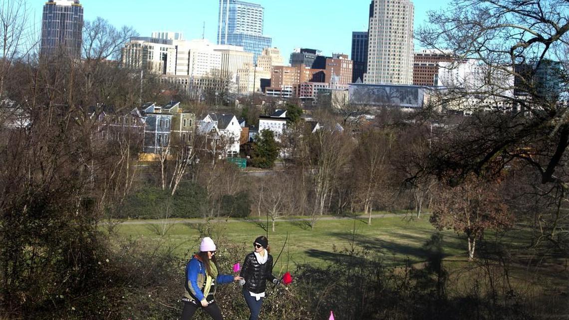 With a backdrop of downtown Raleigh, Clara McDonnell, left, and Katelyn Applegate, walk through the future site of Dix Park last January. A new group, the Dix Park Conservancy, will coordinate planning for the 308-acre park.