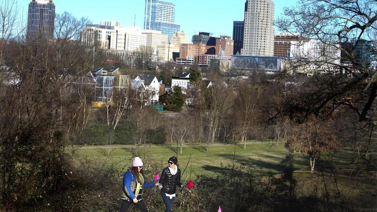 With a backdrop of downtown Raleigh, Clara McDonnell, left, and Katelyn Applegate, walk through the future site of Dix Park last January. A new group, the Dix Park Conservancy, will coordinate planning for the 308-acre park.