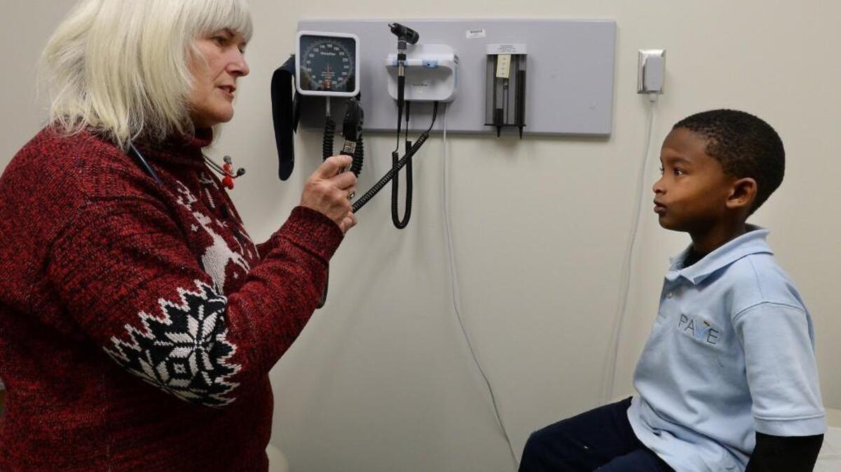 Dr. Margaret Martin gives an eye test to patient Kyntrell Powell, 6, at the newly opened Advance Community Health, formerly Wake Health Services, in southeast Raleigh Wednesday, January 20, 2016. The facility is in a new $13 million facility which features pediatric services and dental services among other things.