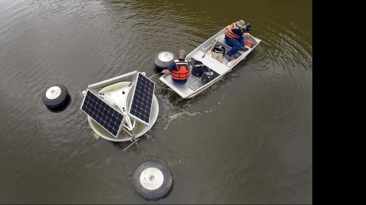 
Jonny Dilworth, left, and Jon Walter, leave the Anderson Creek boat ramp with a SolarBee unit headed for Jordan Lake July 22, 2014. The solar-powered machines redistribute water, which normally would be in a stagnant area of the lake. The state Senate is considering expanding the program by two years.
