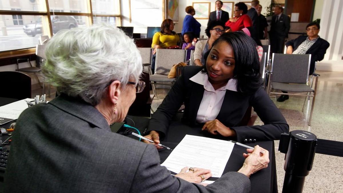 Cherie Poucher, director of the Wake County Board of Elections, left, does the necessary paperwork as Jessica Holmes officially declares herself a candidate at the Wake County Board of Elections in Raleigh on Feb. 20, 2014. Holmes won election to the board.